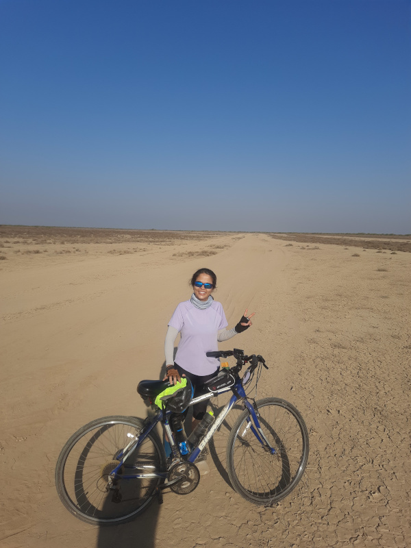 With bicycle on the Chaari desert road.